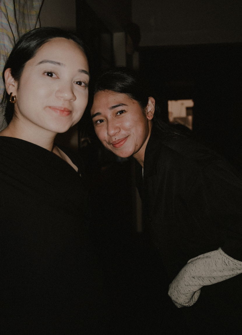 Two women smiling and posing together indoors.