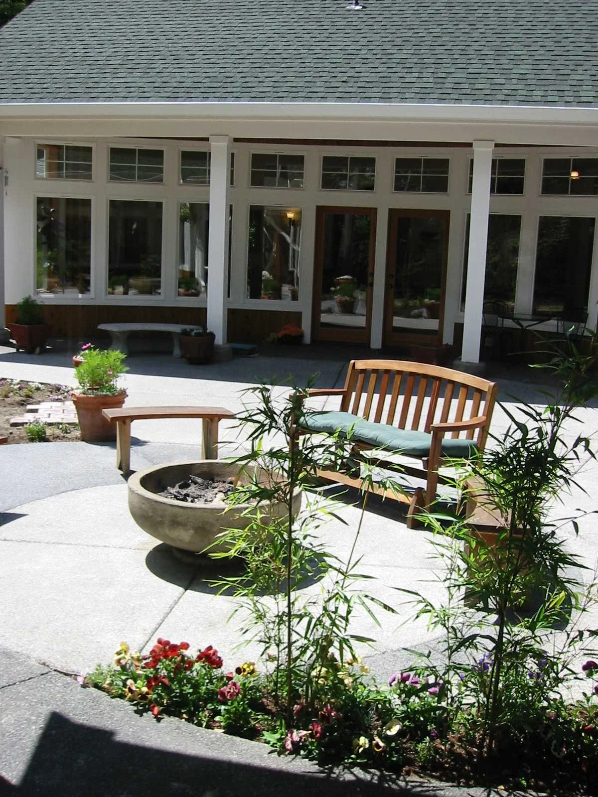 The sweep of the wall connects two separate living suites at the courtyard. Columns help bear the weight of the roof, taking the stress off the wall, so the curve does not have to align with its support.