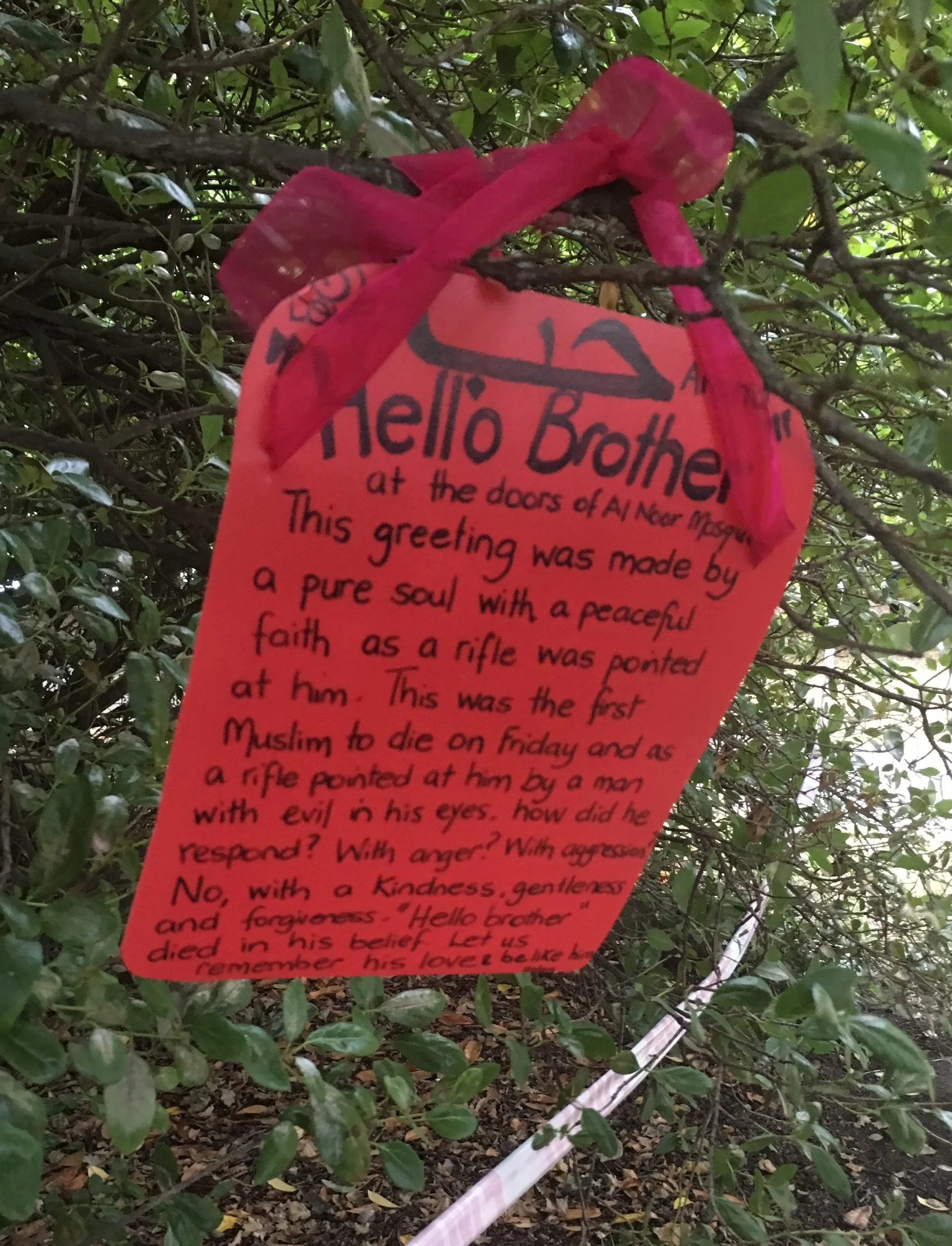 Photo depicts a card tied on to a tree outside the mosque on Deans Avenue