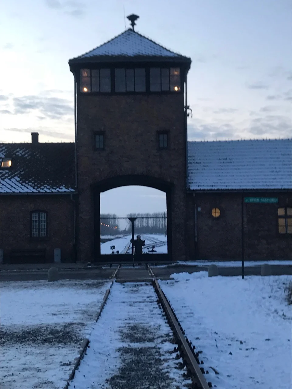 Nancy standing beneath entrance to Auschwitz II Birkeneau