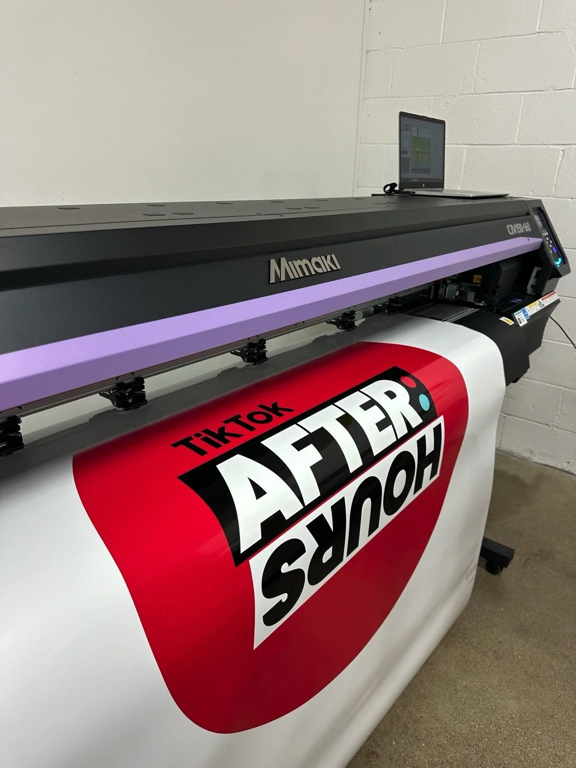 Snaptique printing custom photo booth graphics in-house on our large-format printer
