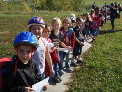 Bike49 Day: the first graders head out on a walk, wearing bike helmets because bike49 does.