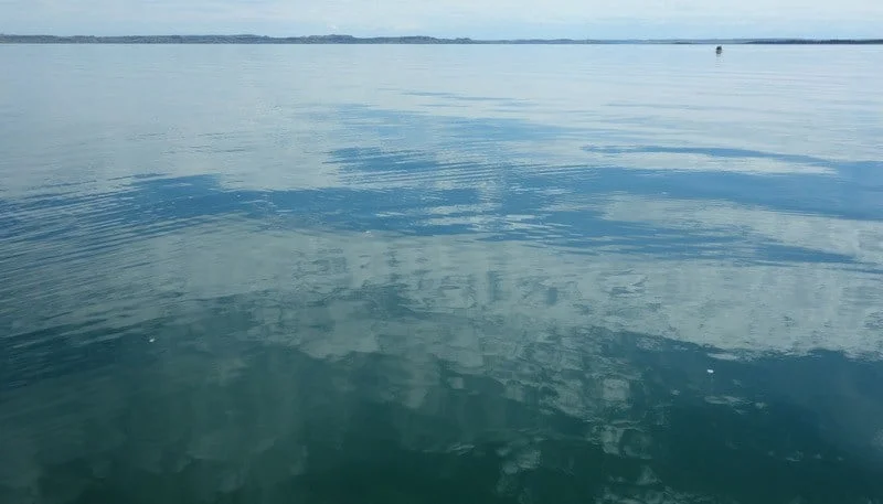 The shore is a distant line and the other canoe just a speck.