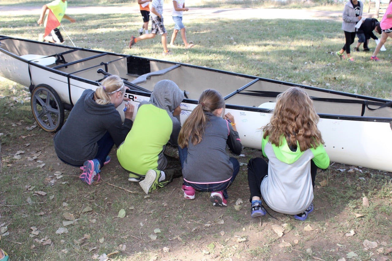 Instead of sending trash down the river, these fifth grade students sign one of our canoes and send their name and a promise to keep the water clean down the river.