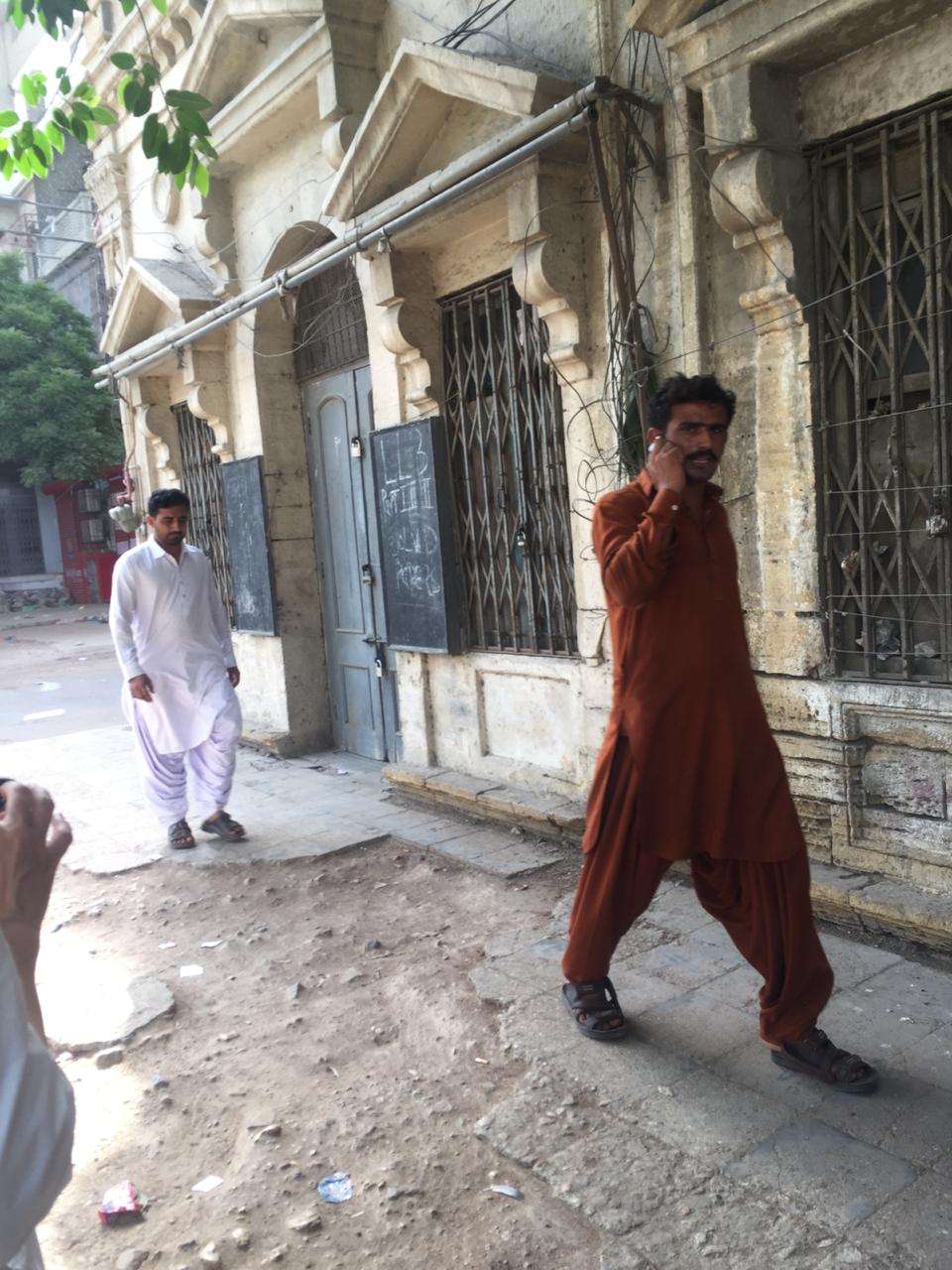 Two men walking on the side-walk in the inner city of Old Town, Karachi | Copyright Marvi Mazhar & Associates