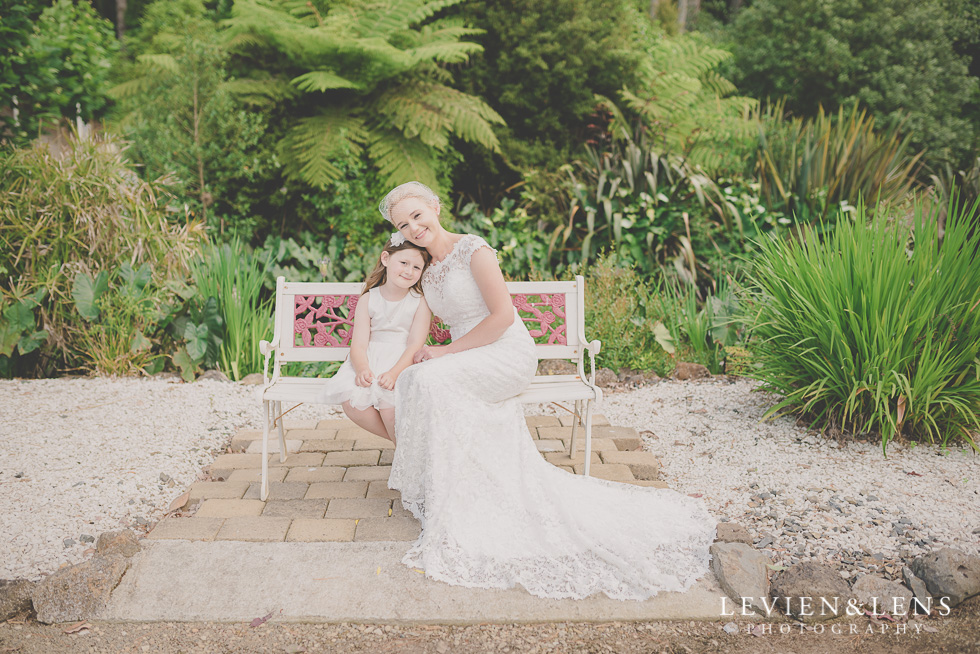 flower girl and stunning bride on bench {Auckland-Hamilton wedding photographer} Footbridge Lodge