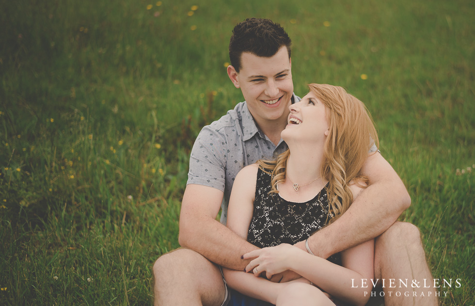couples hug on grass {Auckland-Hamilton lifestyle engagement-wedding photographer}