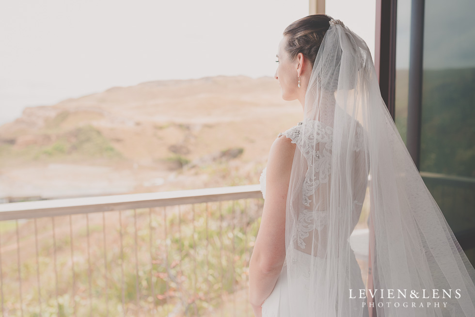 bride look at window Castaways Resort - Kariotahi beach wedding {Auckland lifestyle couples-engagement photographer}