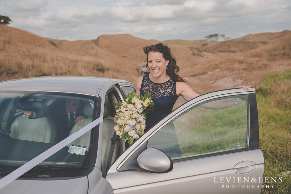 bridesmaid near car bride groom location shoot Kariotahi beach Castaways {Auckland wedding-engagement-couples photographer}