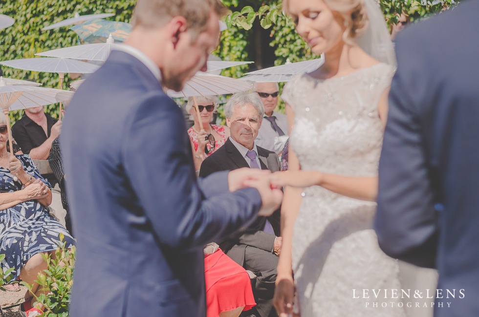 groom putting ring on bride hand {Tauranga-Bay of Plenty wedding-couples-engagement photographer}