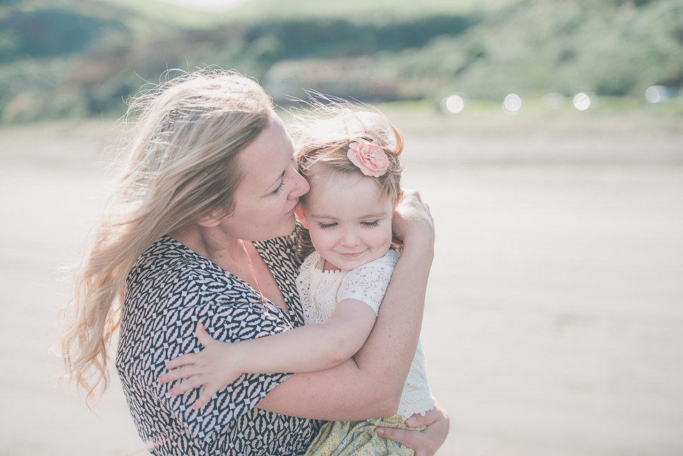 mum kissing daughter Kariotahi beach photo shoot {Auckland lifestyle family-kids photographer}