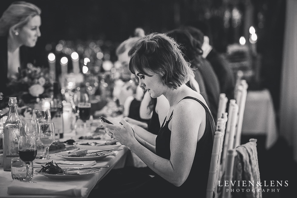 bridesmaid with phone - reception - St Margarets Cafe - Karaka {Auckland lifestyle wedding photographer}