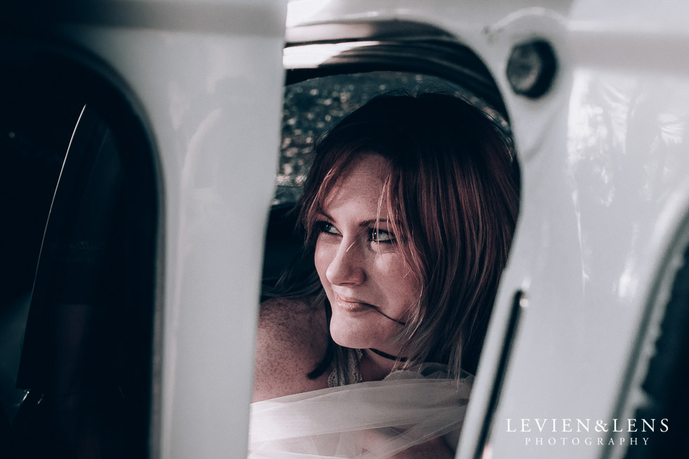 bride looking from the retro car - Cornwall park photo session - winter wedding {Auckland NZ lifestyle weddings photographers}