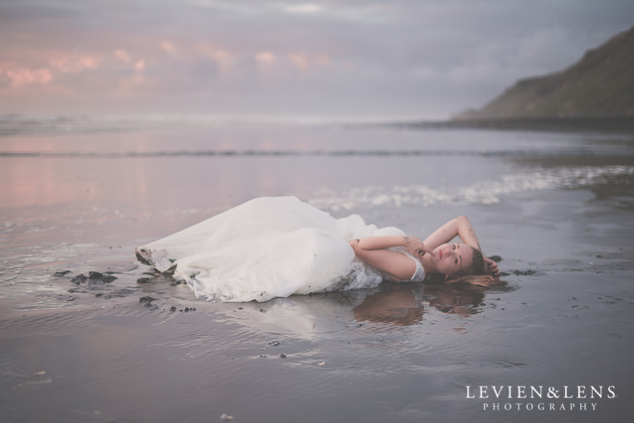 bride portrait laying on beach sunset {Auckland wedding photographer} Castaways Kariotahi