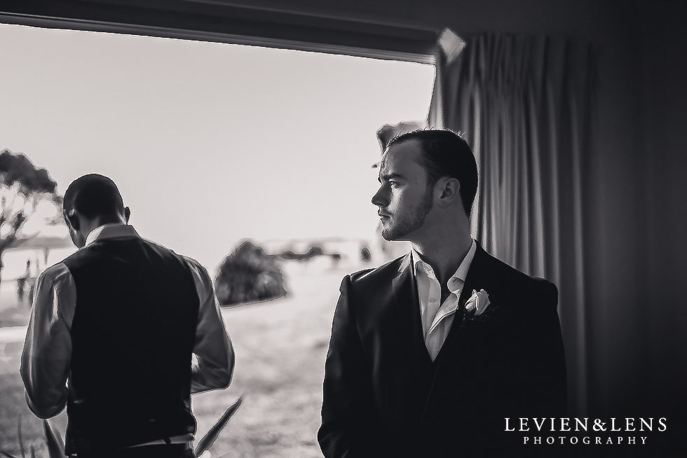 groom getting ready near window - Formosa wedding Golf Resort {Auckland weddings photographer}