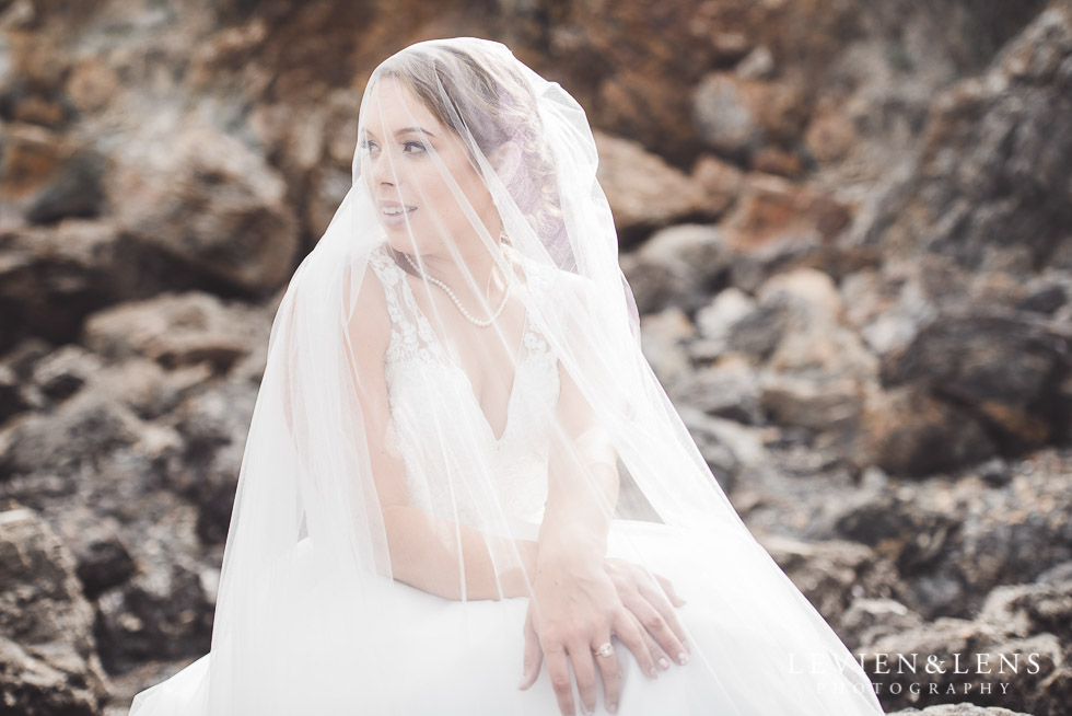 bridal portraiture - bride under veil sitting on rocks - The Duke of Marlborough Hotel - Russel wedding {Northland-New Zealand weddings photographer} beach