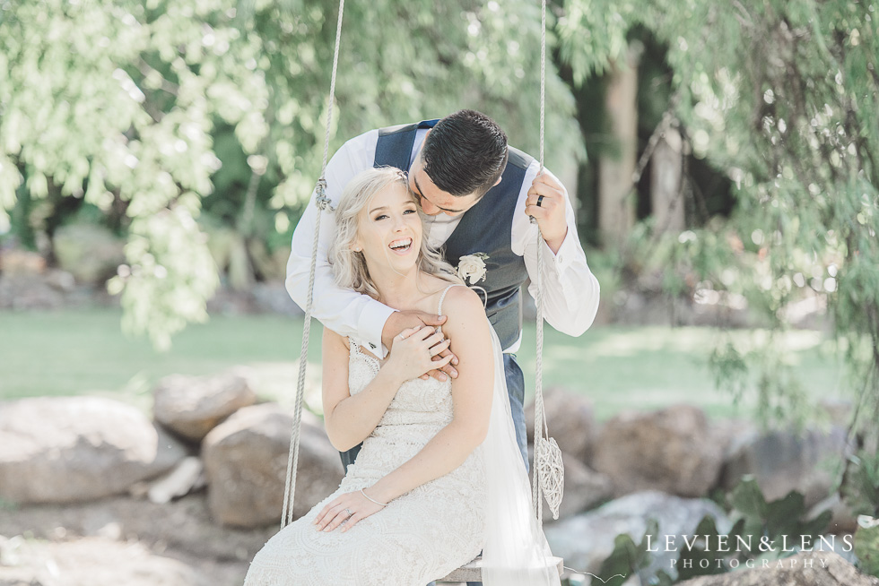 bride with groom on swing- Liddington Gardens - Kerkeri Northland {NZ destination wedding photographer}