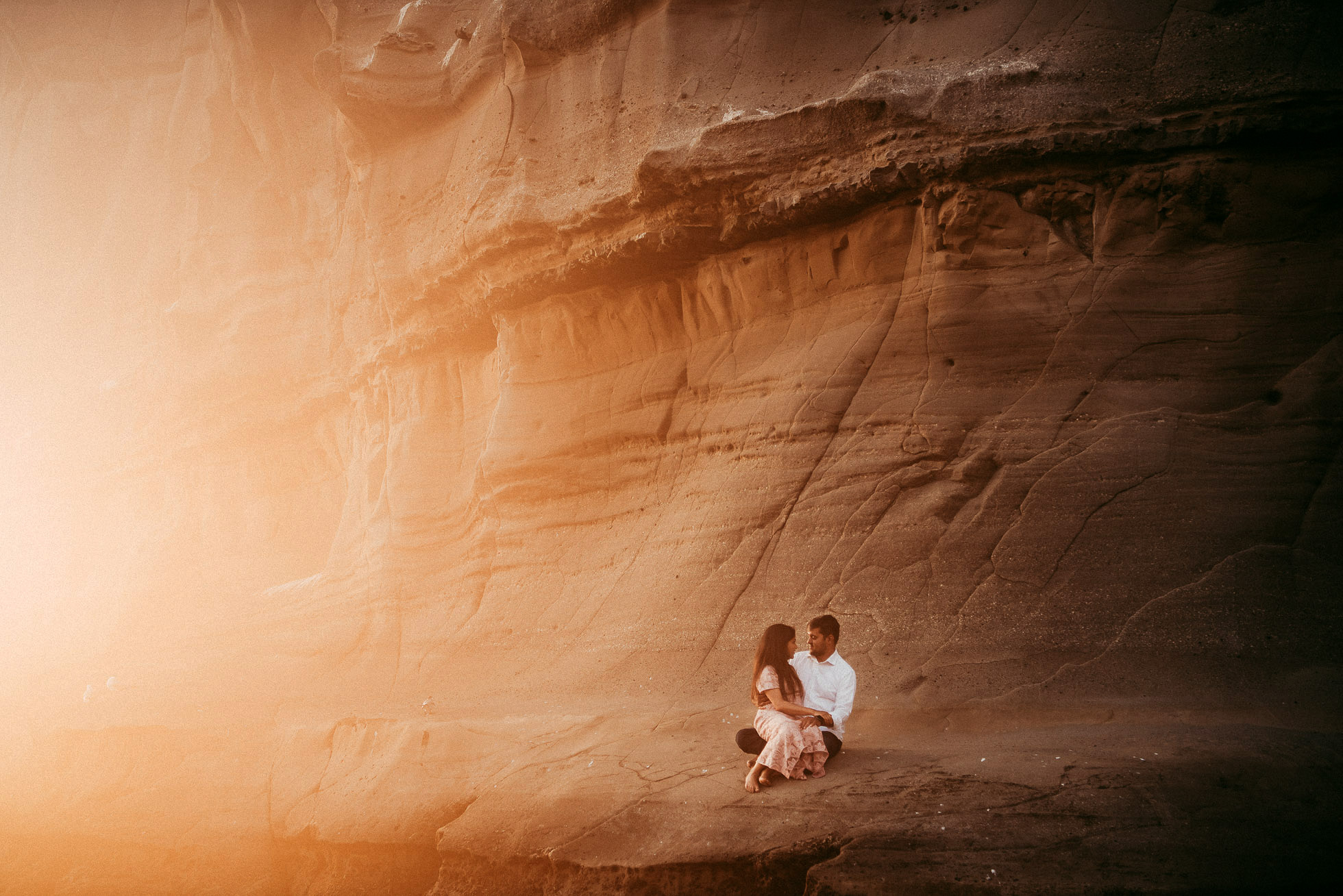 couple sitting on the rocks - Auckland engagement | pre-wedding photographer
