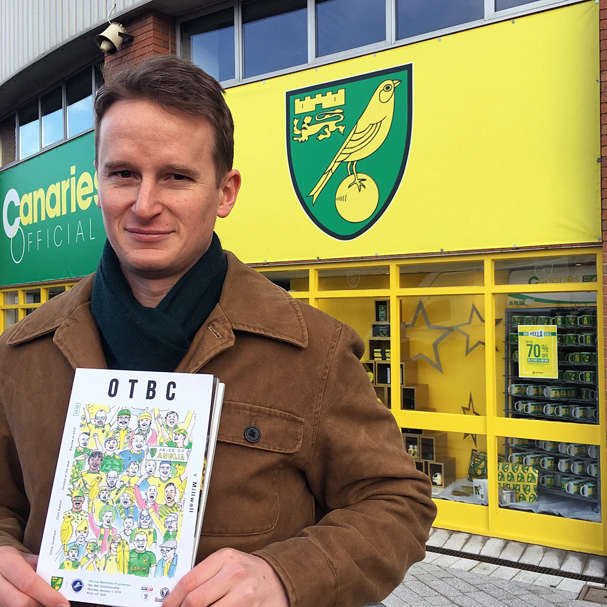 Myself on matchday with the programme featuring my illustration