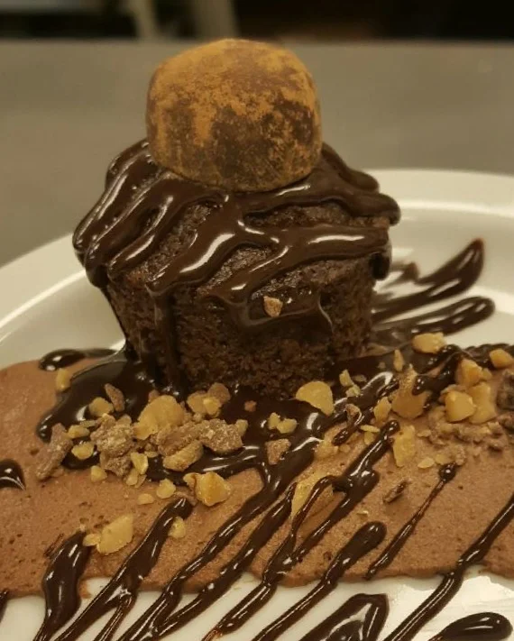 Chocolate Chocolate Chocolate! Our delectable Juniper Spoon chocolate cake topped with an espresso truffle, all served over chocolate mousse, toffee crumbles, and chocolate sauce drizzle.