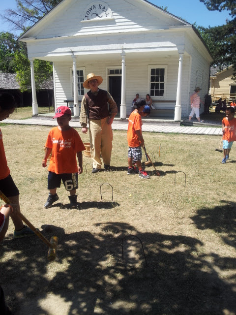 Filipino Pioneers learning how to play (or how not to play) croquet at Black Creek Pioneer Village