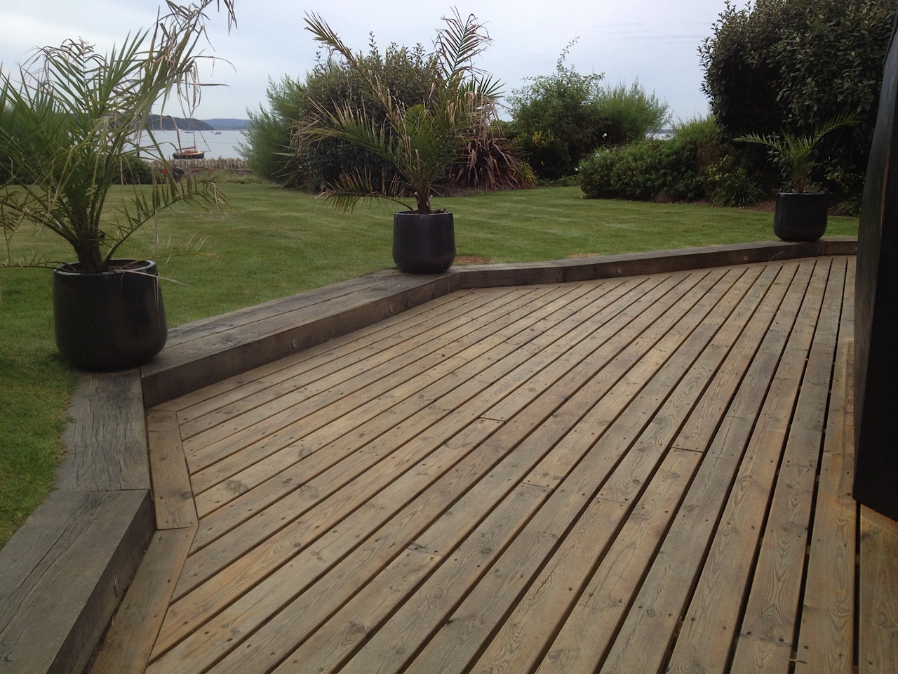 Smooth Decking sunken with oak sleepers to retain lawn