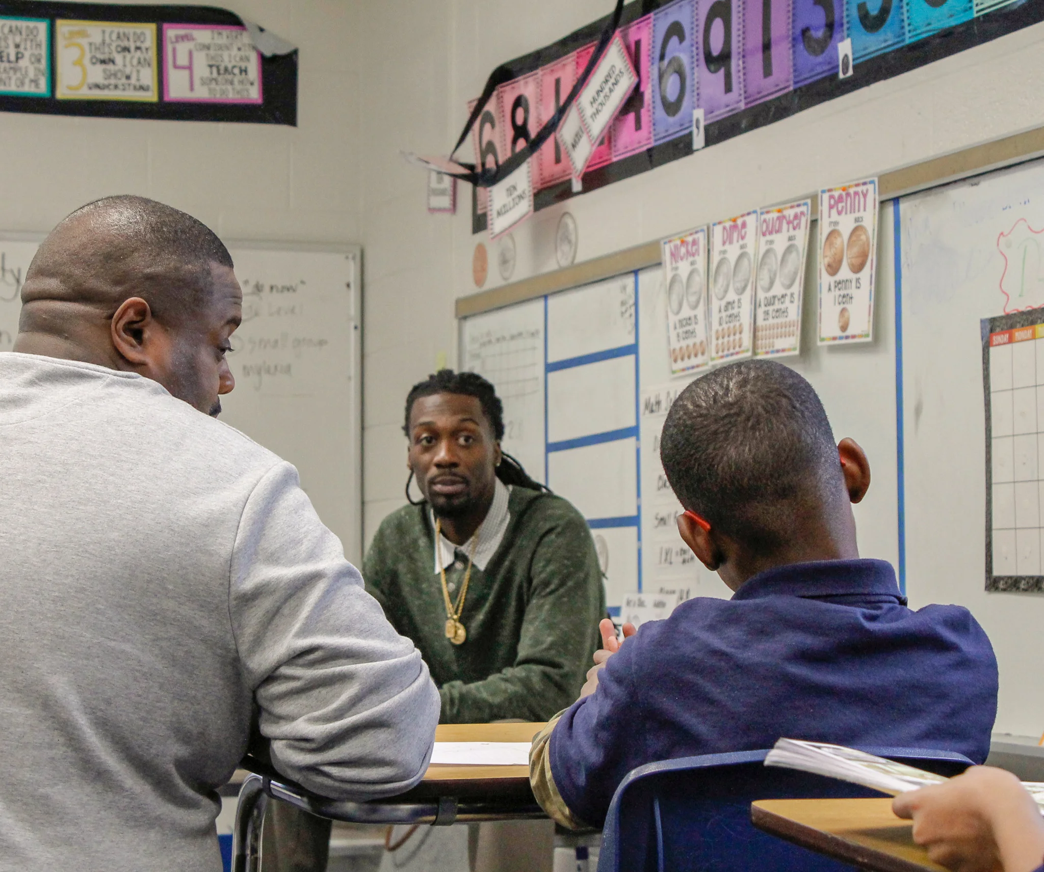 Mr. Alexander and Mr. Neal speak with a student.