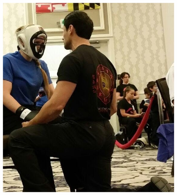 Master Ozuna coaches Katie Schmid between rounds of a Lei Tai match