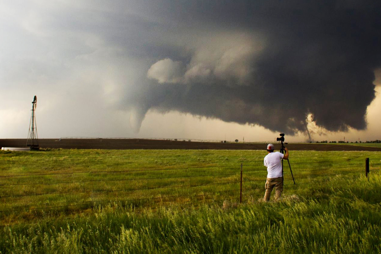 Me setting up my camera as two tornadoes touch down outside of Dodge City, Ks. Image credit Brendon Lindsey. 
