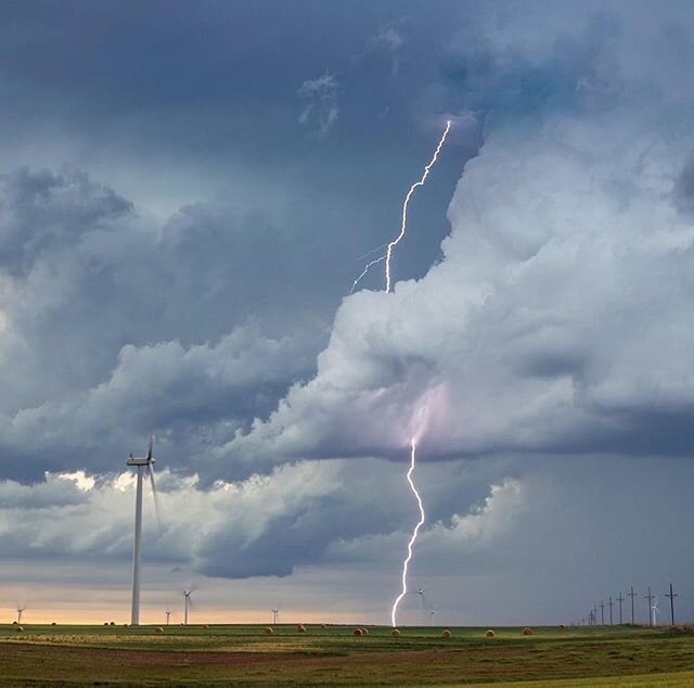 Lightning leaps from the updraft of a supercell in Minneola, Kansas on May 24, 2020. It appears the channel hit the blade of the wind turbine before arcing to ground. The storm was dropping tennis ball size hail at the time. 
#windmill #turbine #weat