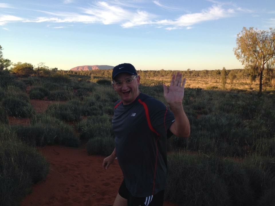 Early morning run through the red dunes with Ayers Rock in the background. 