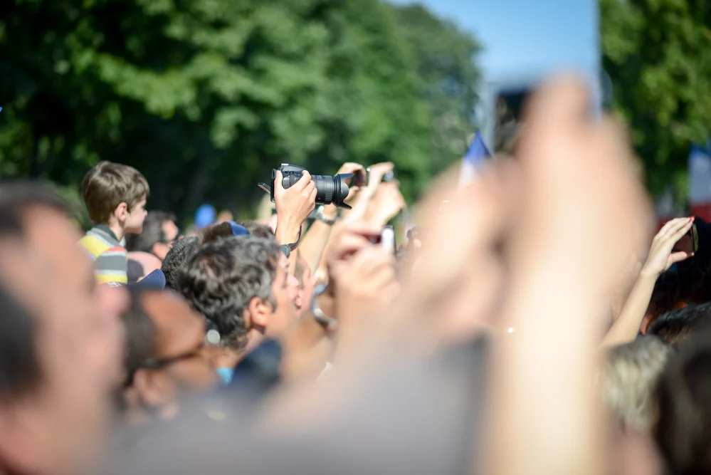 Man-Taking-Photo-In-Crowd-Of-People.jpg