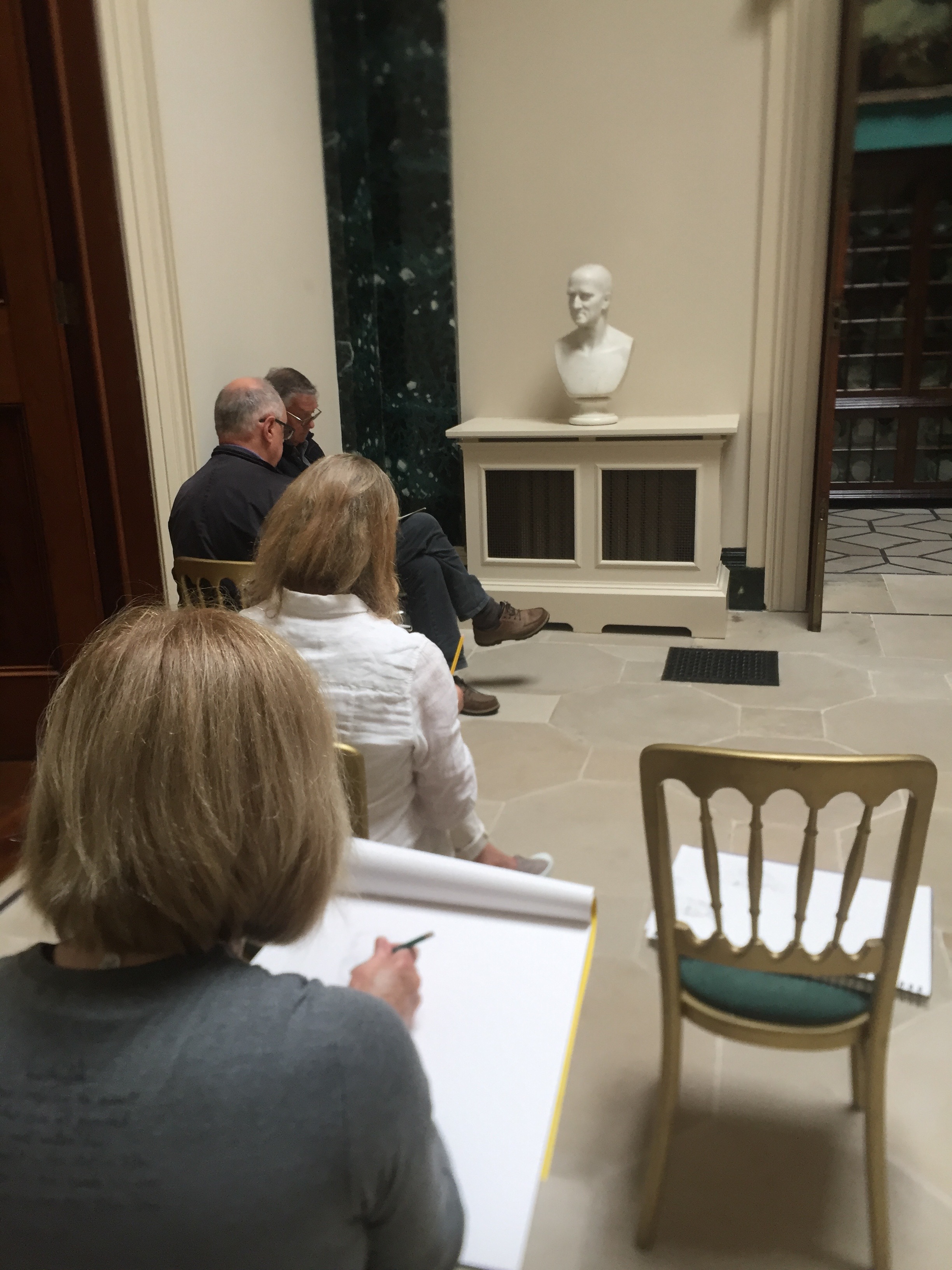 Students drawing one of the busts.