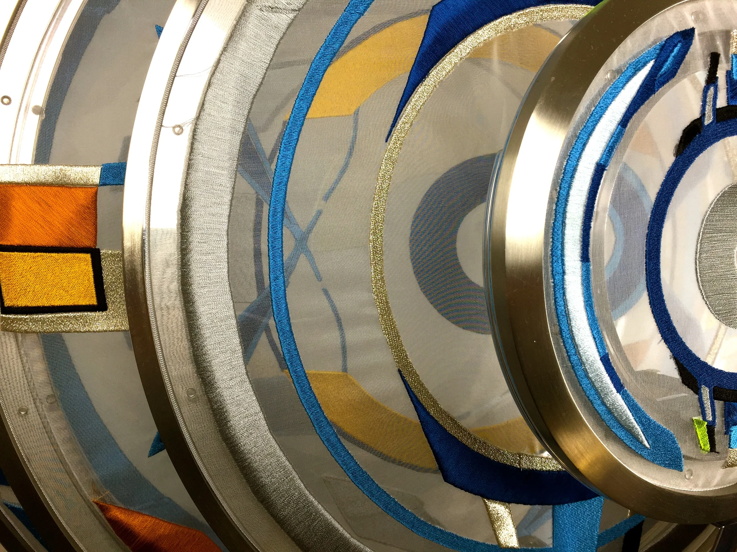  Each hoop is embroidered with its own design and corresponding hue, and the translucent material allows them to be seen separately or together, allowing for multiple interpretations and a new consideration of the eye’s obligatory need to integrate t