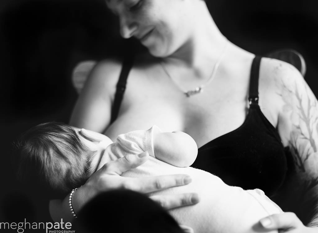 A black and white image of a mother breastfeeding her child