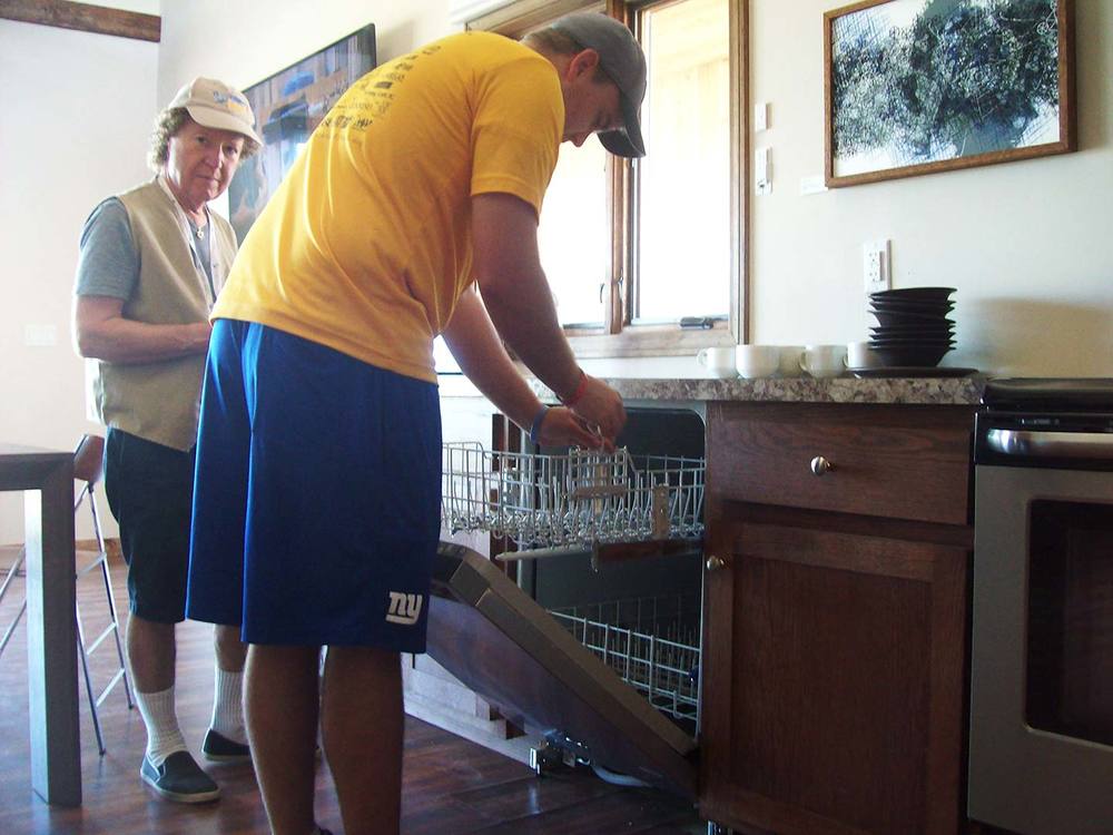 Dylan Tucker installing sensor in Team Alfred's dishwasher.