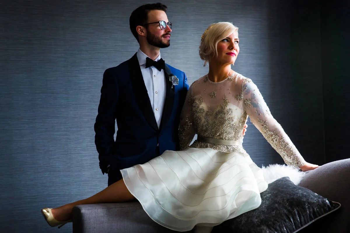 Stella Blue Design bride and groom Allie and Michael pose together on their wedding day. Allie wears an embellished long-sleeve wedding dress while Michael wears a dark tuxedo with a bow tie.