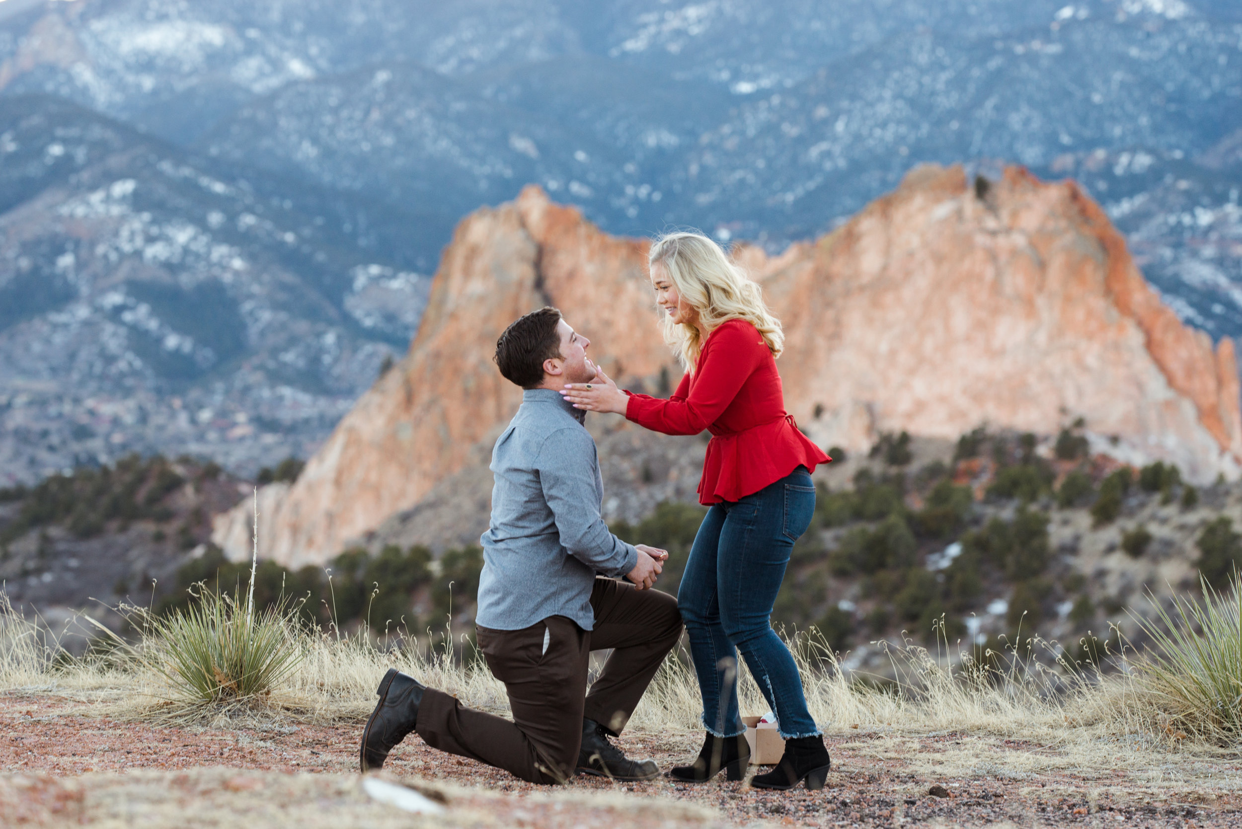 Christine embraces Blaine after he proposes with the Colorado mountains in the background.