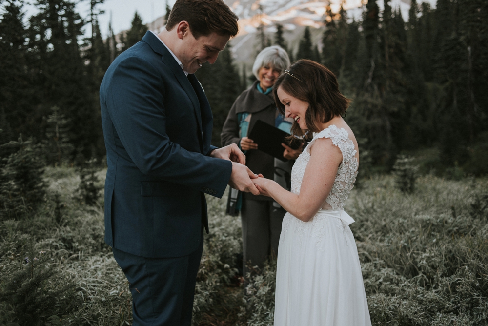 groom putting ring on bride
