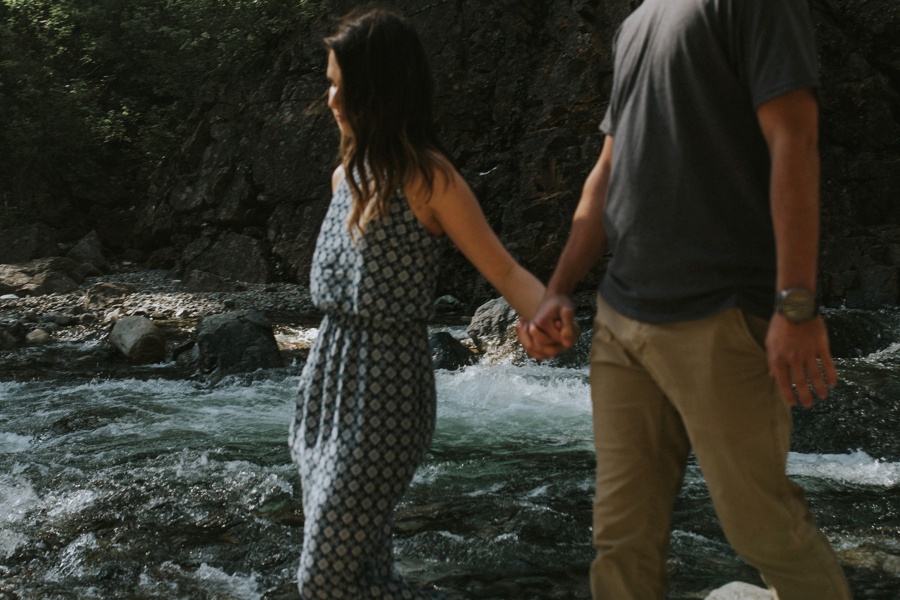 couple holding hands at river