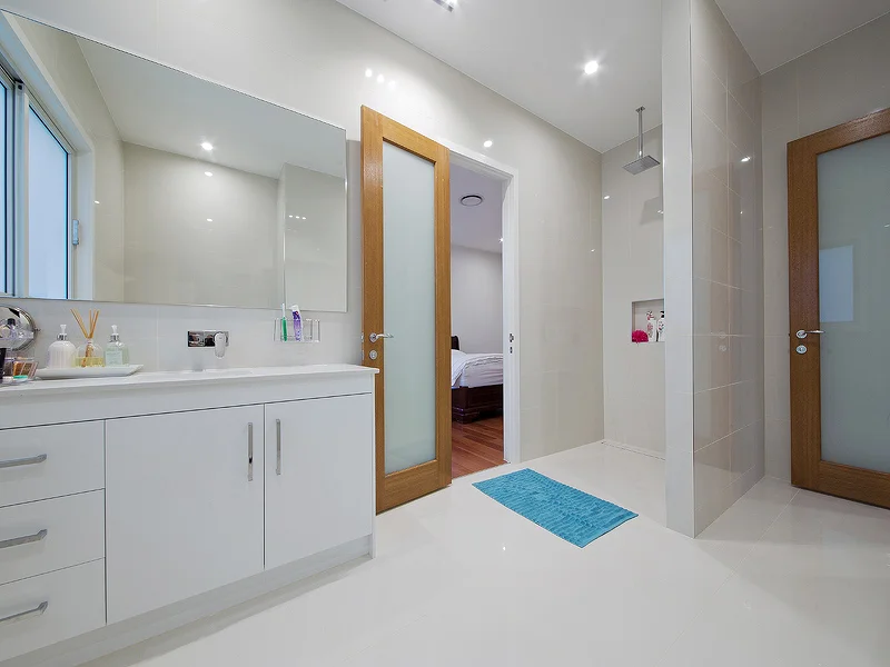 Guest bathroom with open shower and stone vanity. House design by Empire Design & Drafting