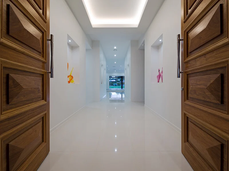 Double timber entry doors, 3.5m high ceilings with bulkhead and feature lighting. House design by Empire Design & Drafting