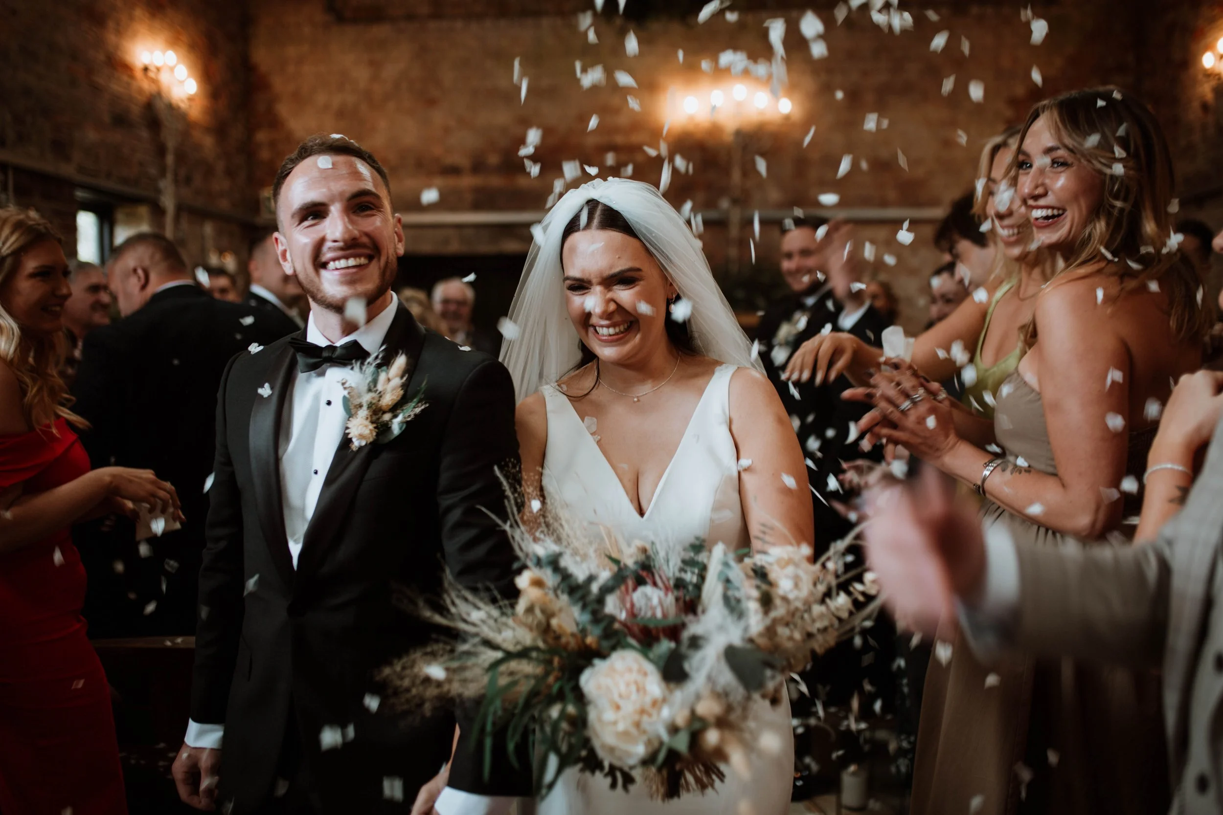 A bride and groom walk through a shower of confetti at the Barn at Botley Hill.