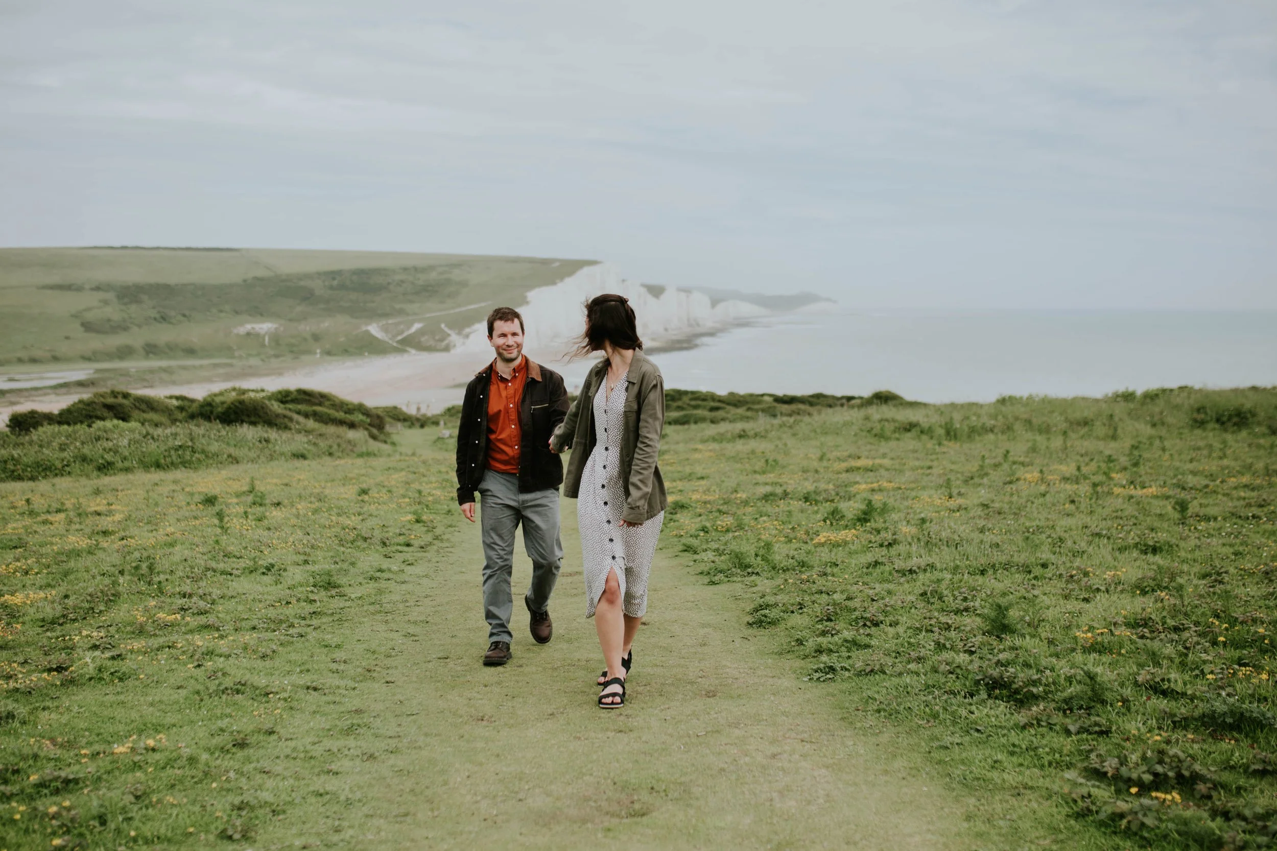 Engaged couple laughing together as they discuss wedding plans.