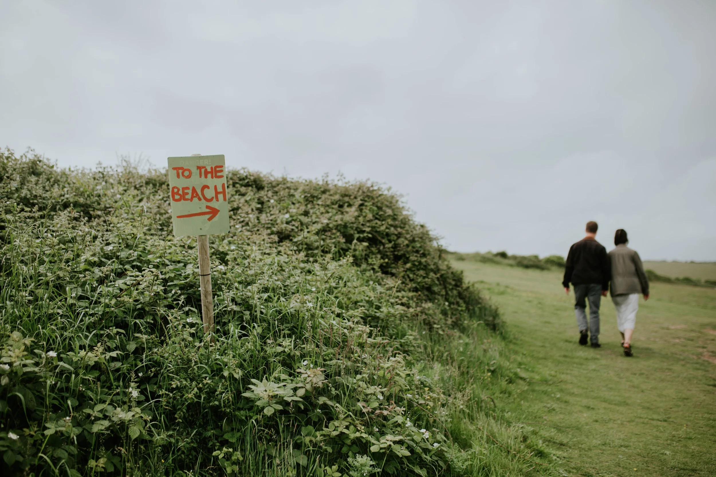Newly engaged couple walk to the beach