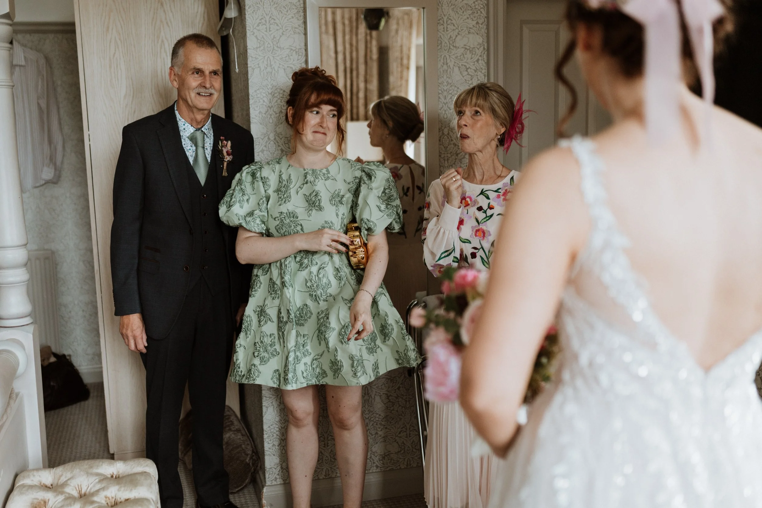  The brides family react to seeing their daughter and sister for the first time in her wedding dress.  
