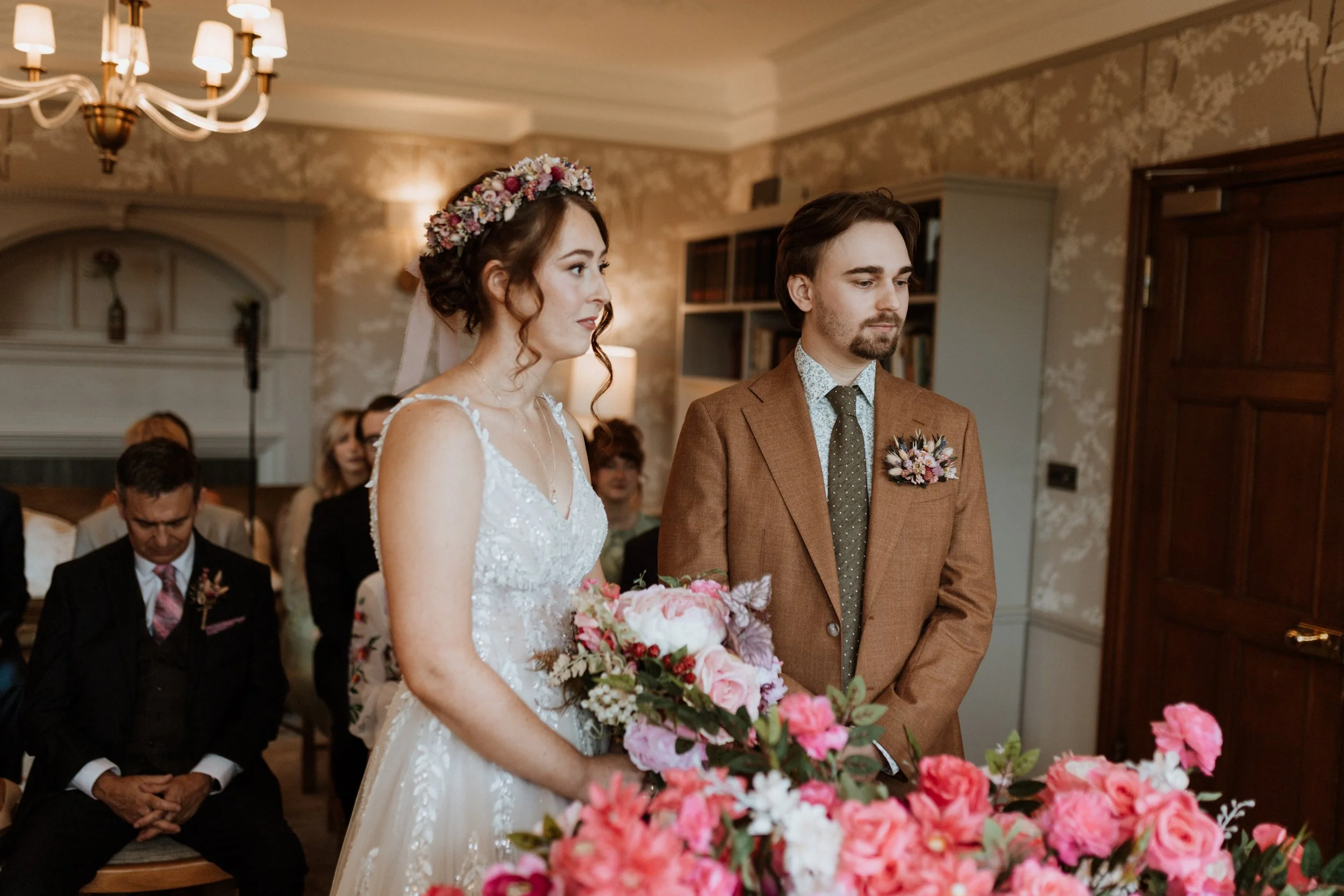  A bride and groom stand together during their ceremony in the Lake District.  