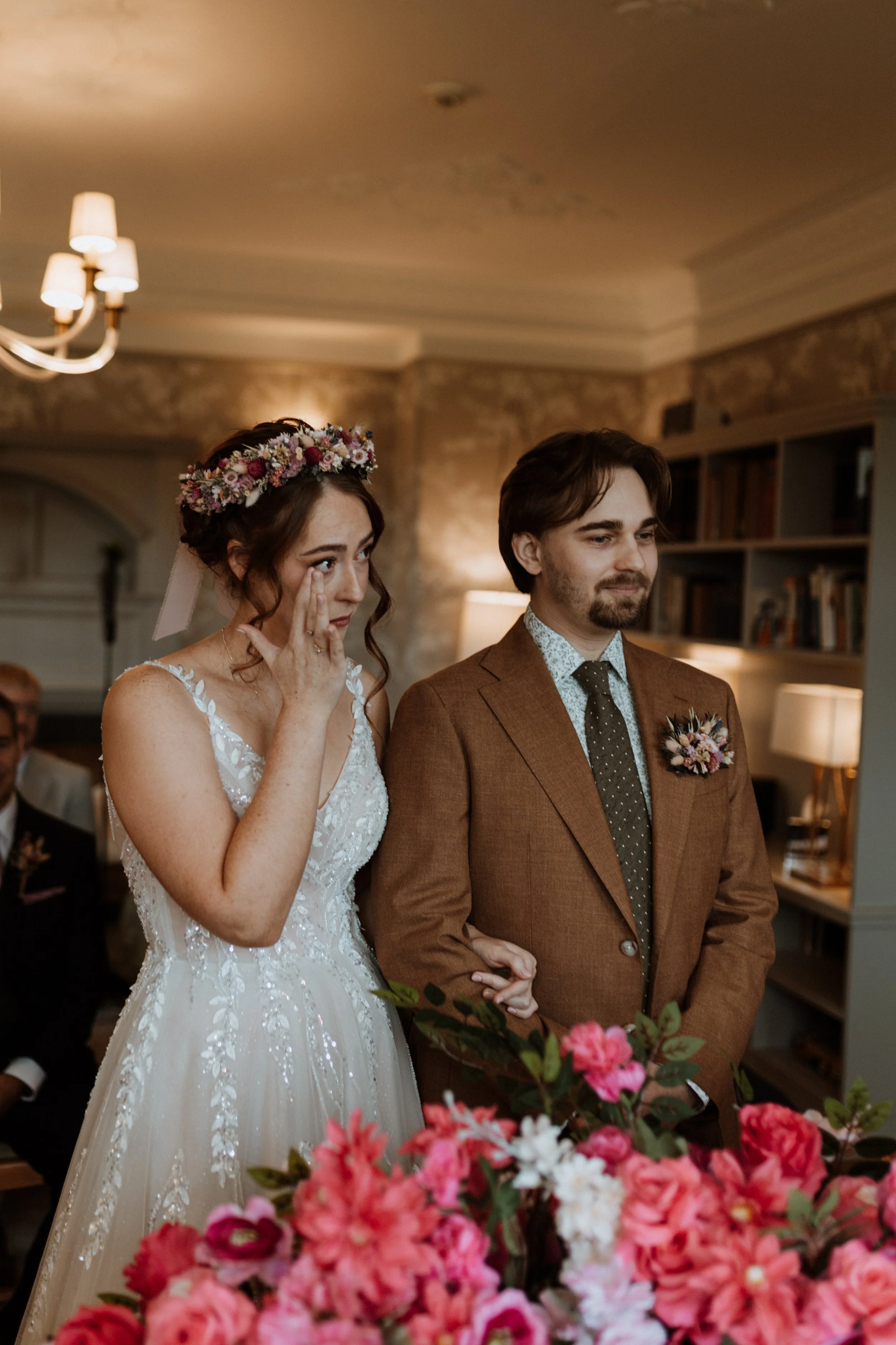  The bride wipes a tear during their ceremony in the Lake District.  