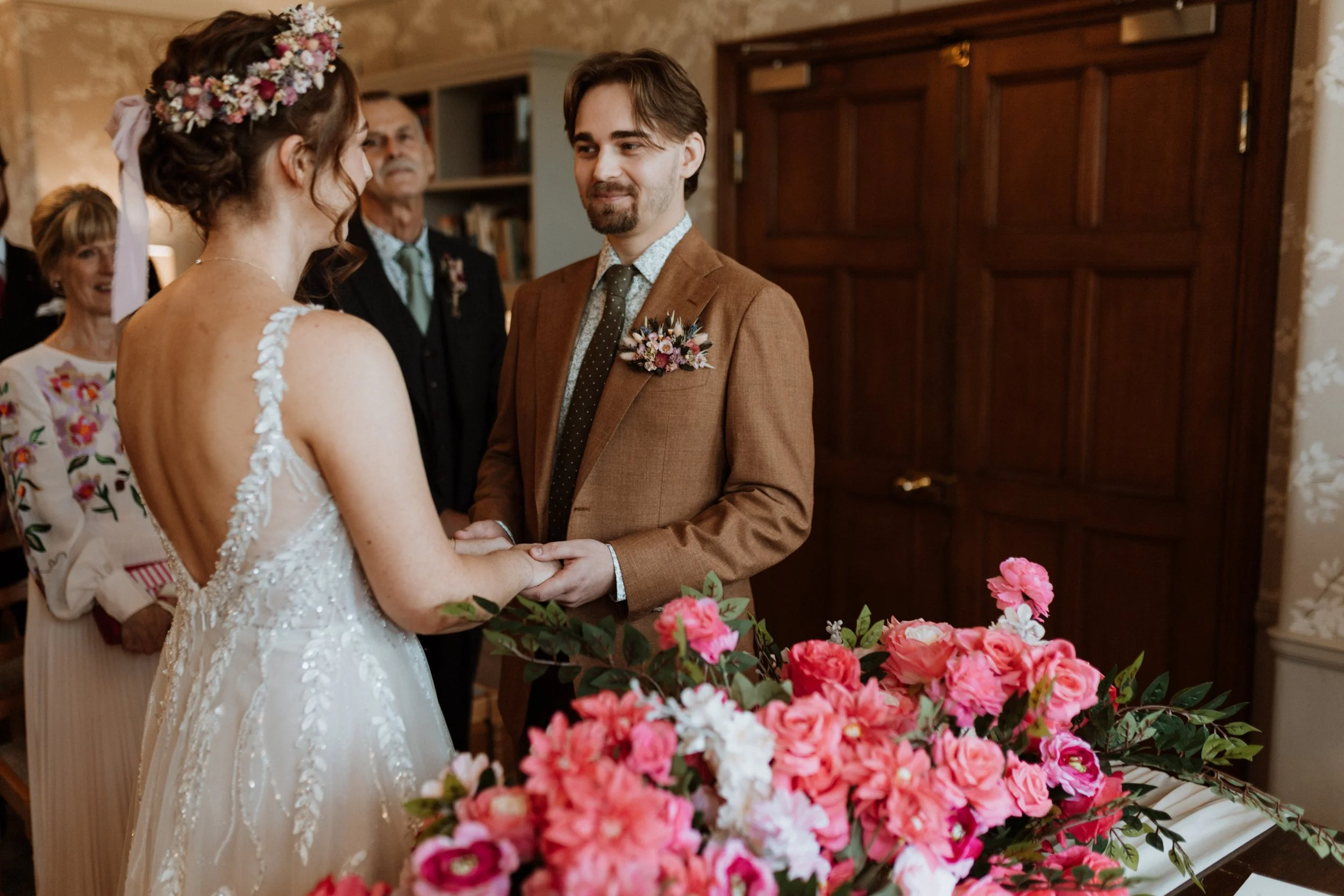  The bride and groom hold hands during their ceremony at Cragwood Hotel.  