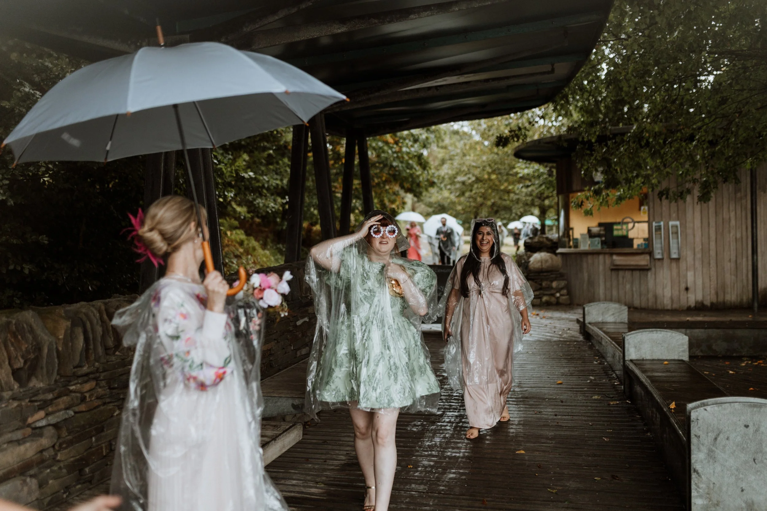  Their guests walk together under umbrellas and ponchos as it rains in the Lake District.  